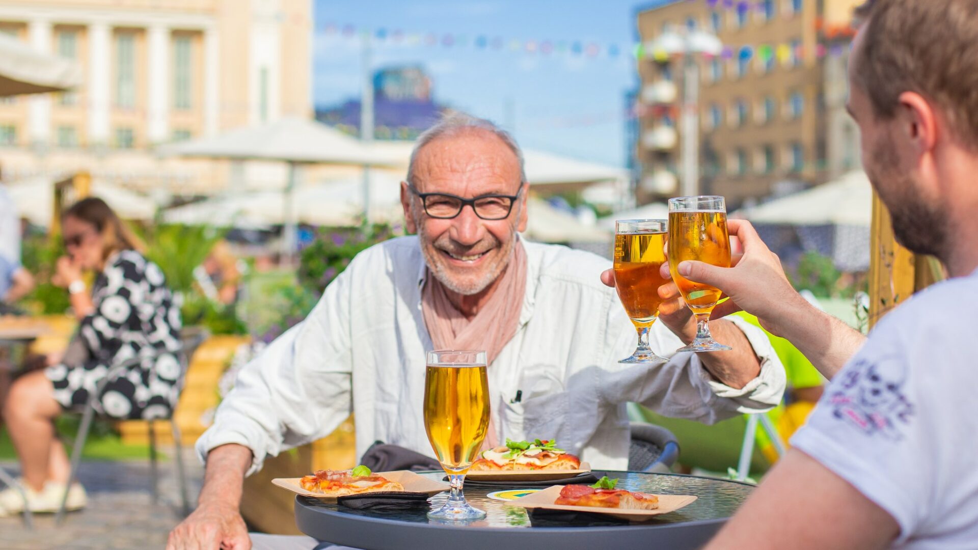 Two people having beers at the Summer terrace and restaurants.